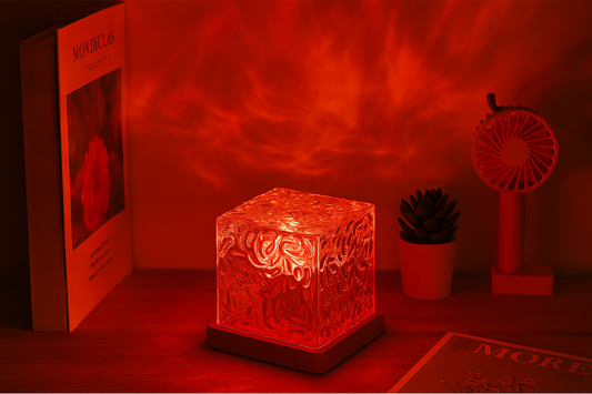 Glass cube night light projecting red ambient lighting in a cozy bedroom scene.