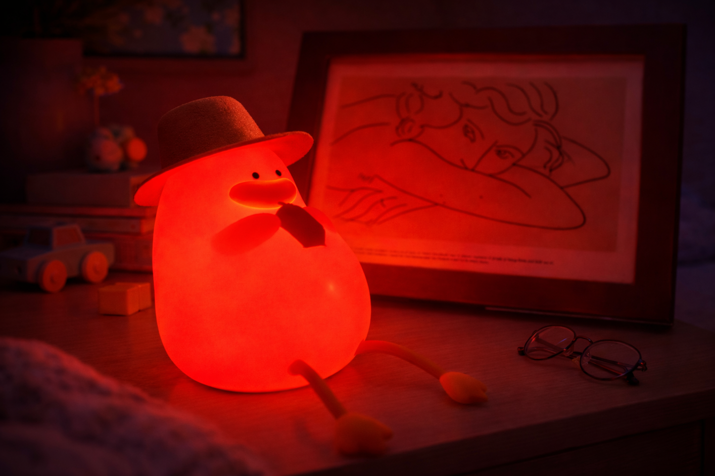 Color-changing silicone duck night light glowing red in a dim bedroom setting