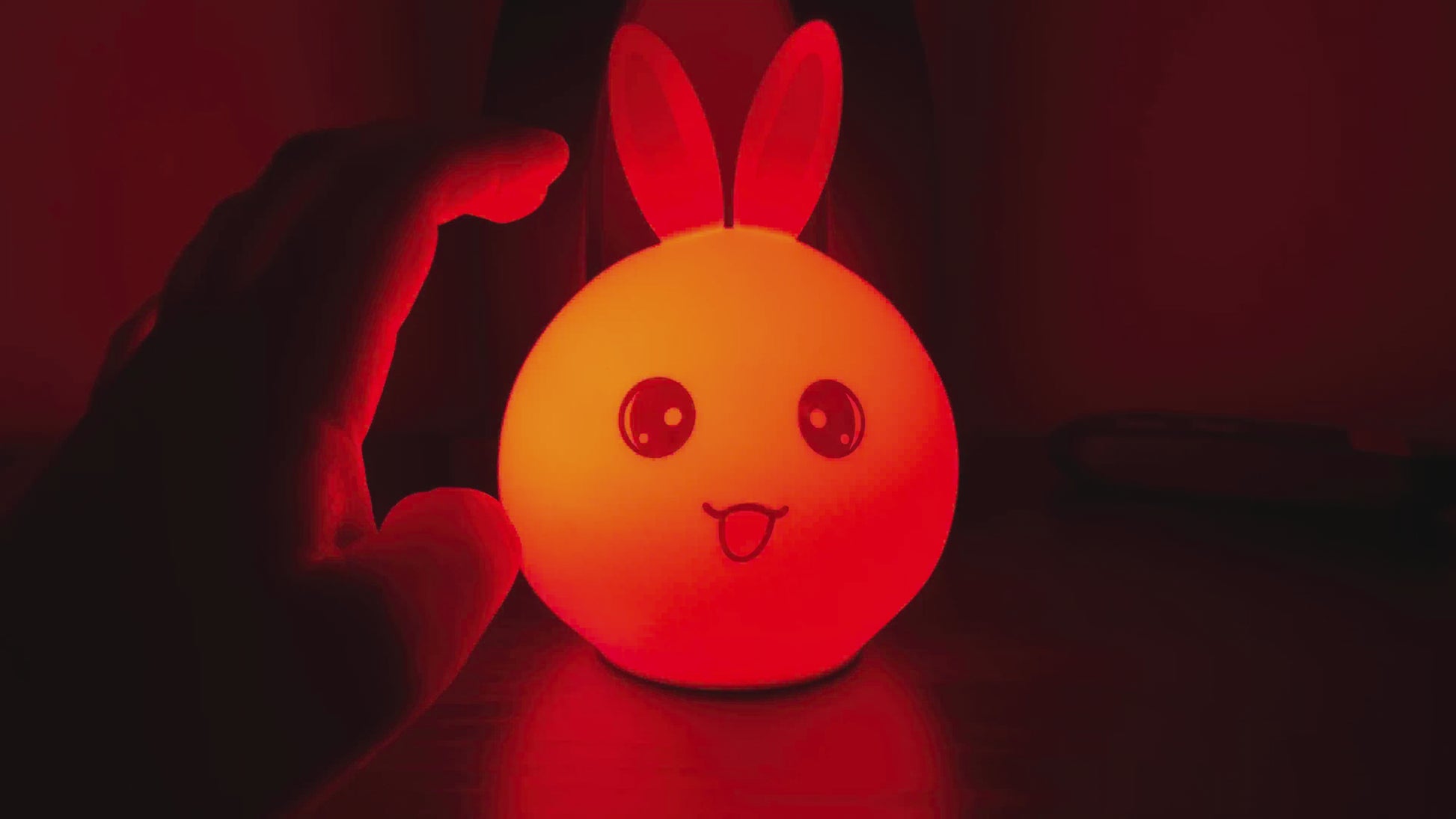 Color-changing silicone bunny night light glowing in a dark room