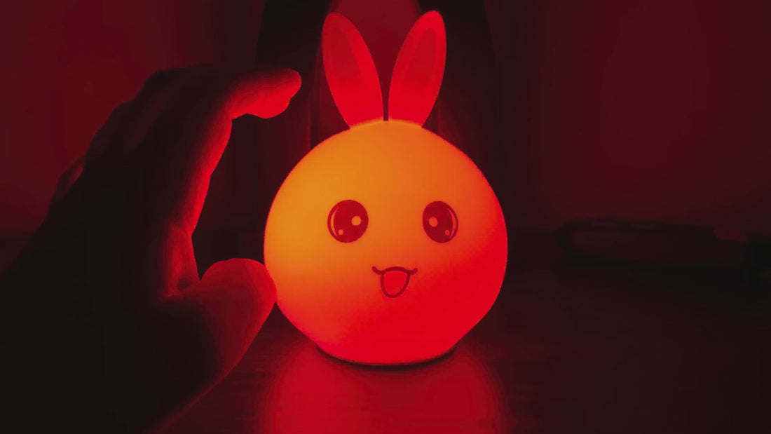Color-changing silicone bunny night light glowing in a dark room